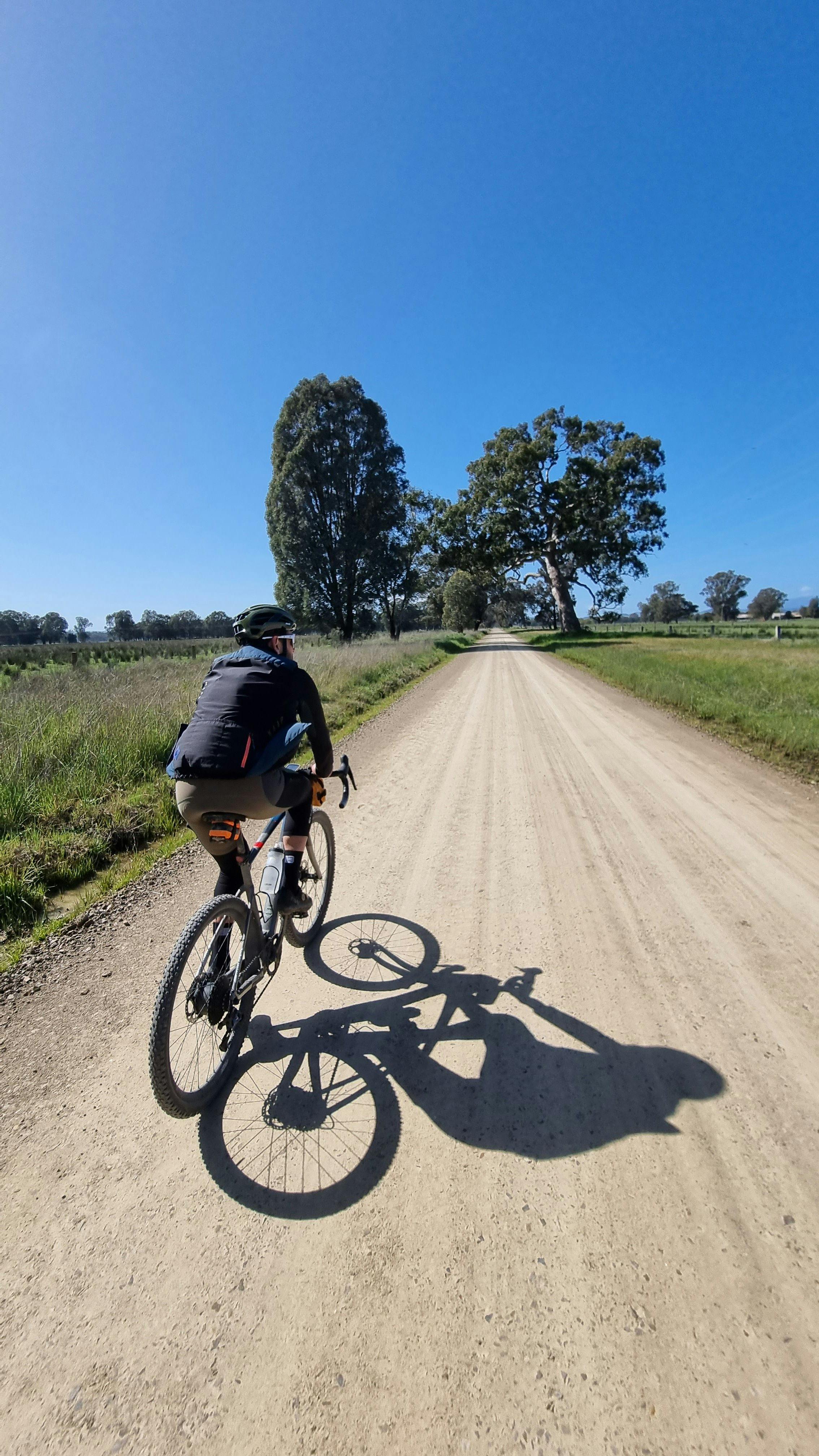 Cyclist in foreground on Gravel Road