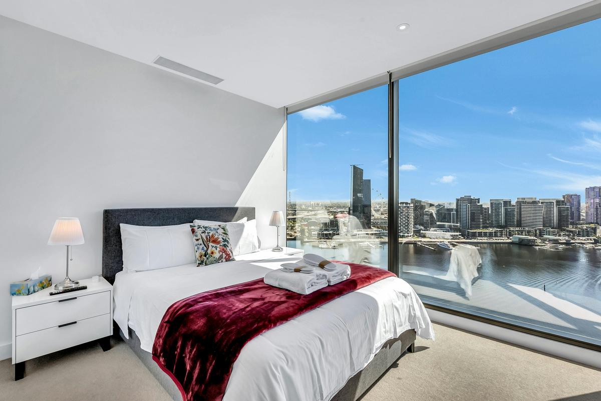 Queen bed with towels and slippers