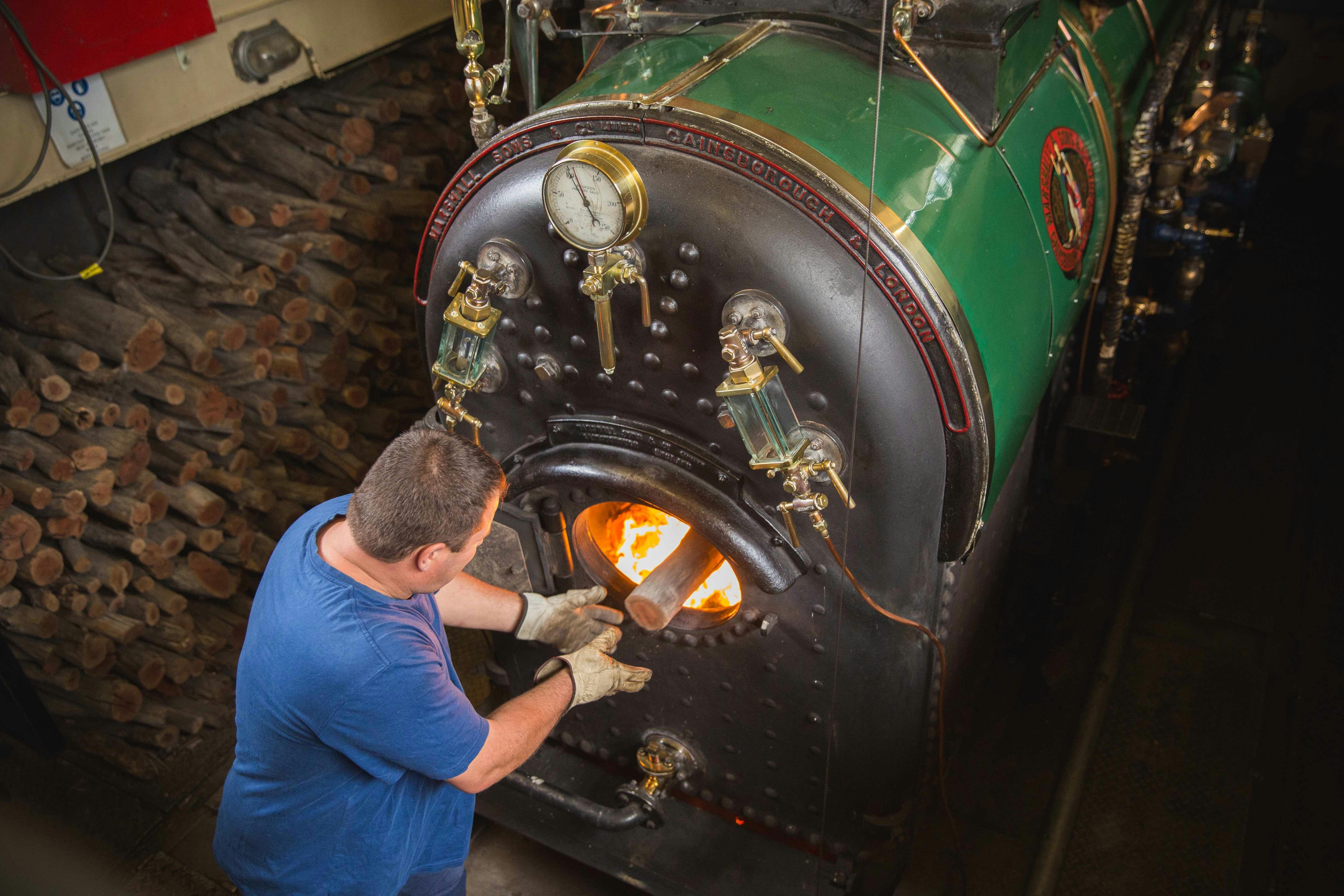 Engineer keeping steam up with Redgum logs