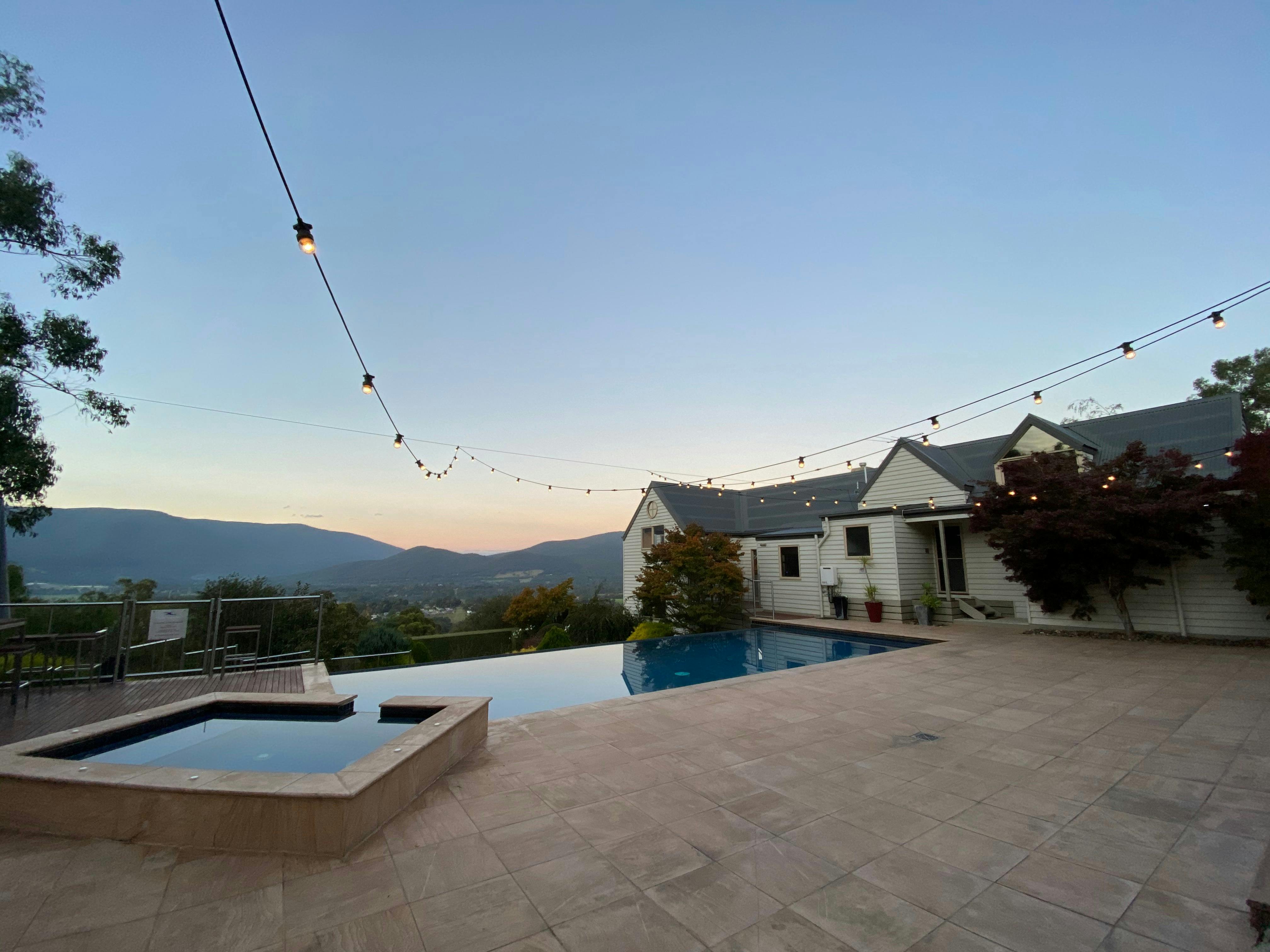 Festoon lights create a beautiful ambience over the horizon edge pool and 6 person spa