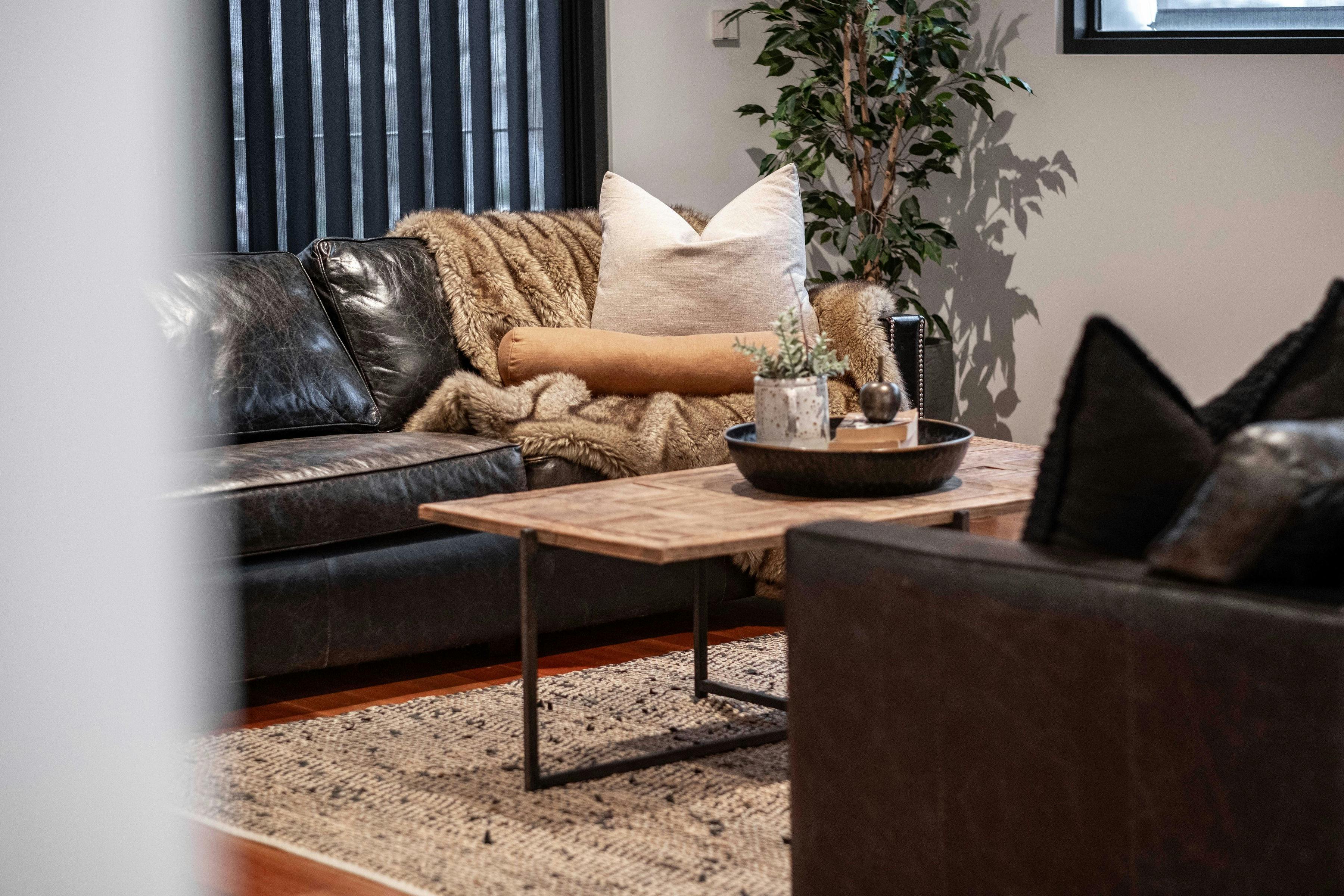 Olsen Penthouse living room with cosy couches, tea table and a plant in the background