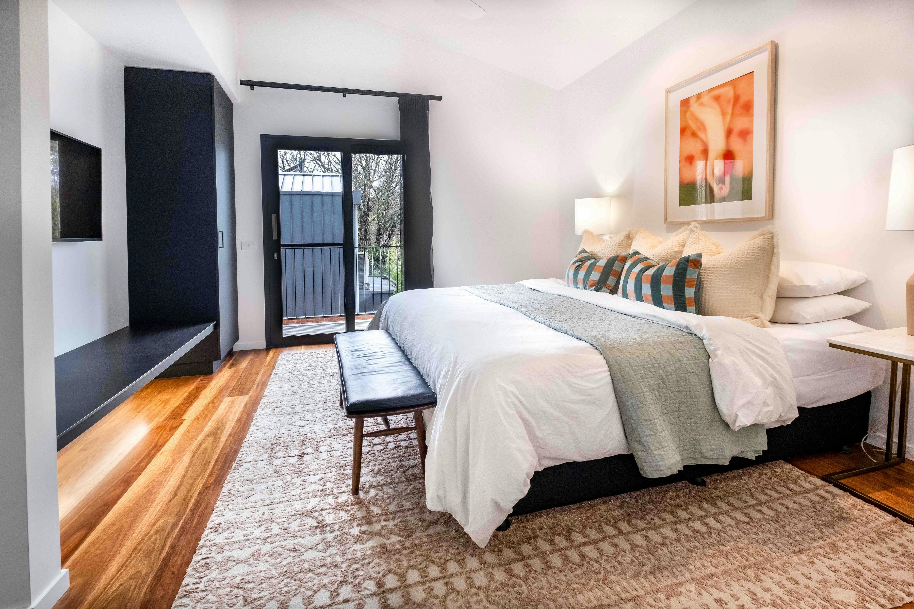 Olsen Penthouse bedroom with bed, bedside lamps, television and a wardrobe