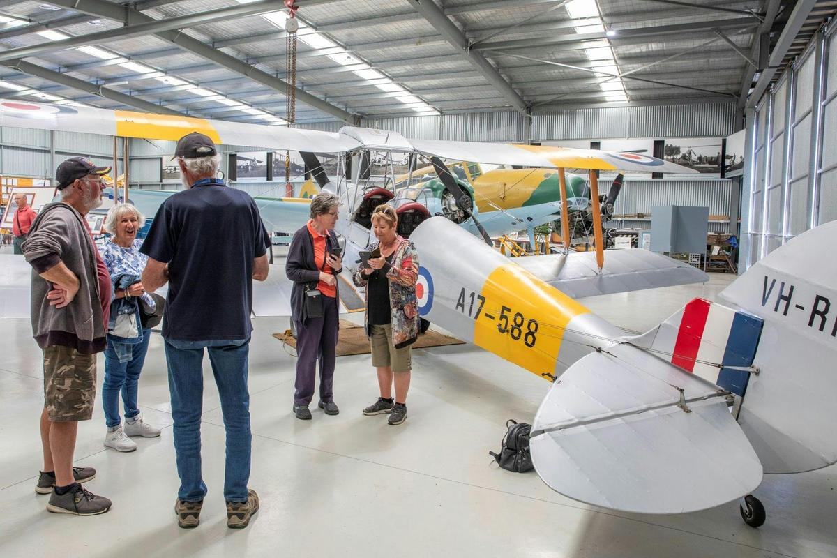 A group of people standing next to a plane