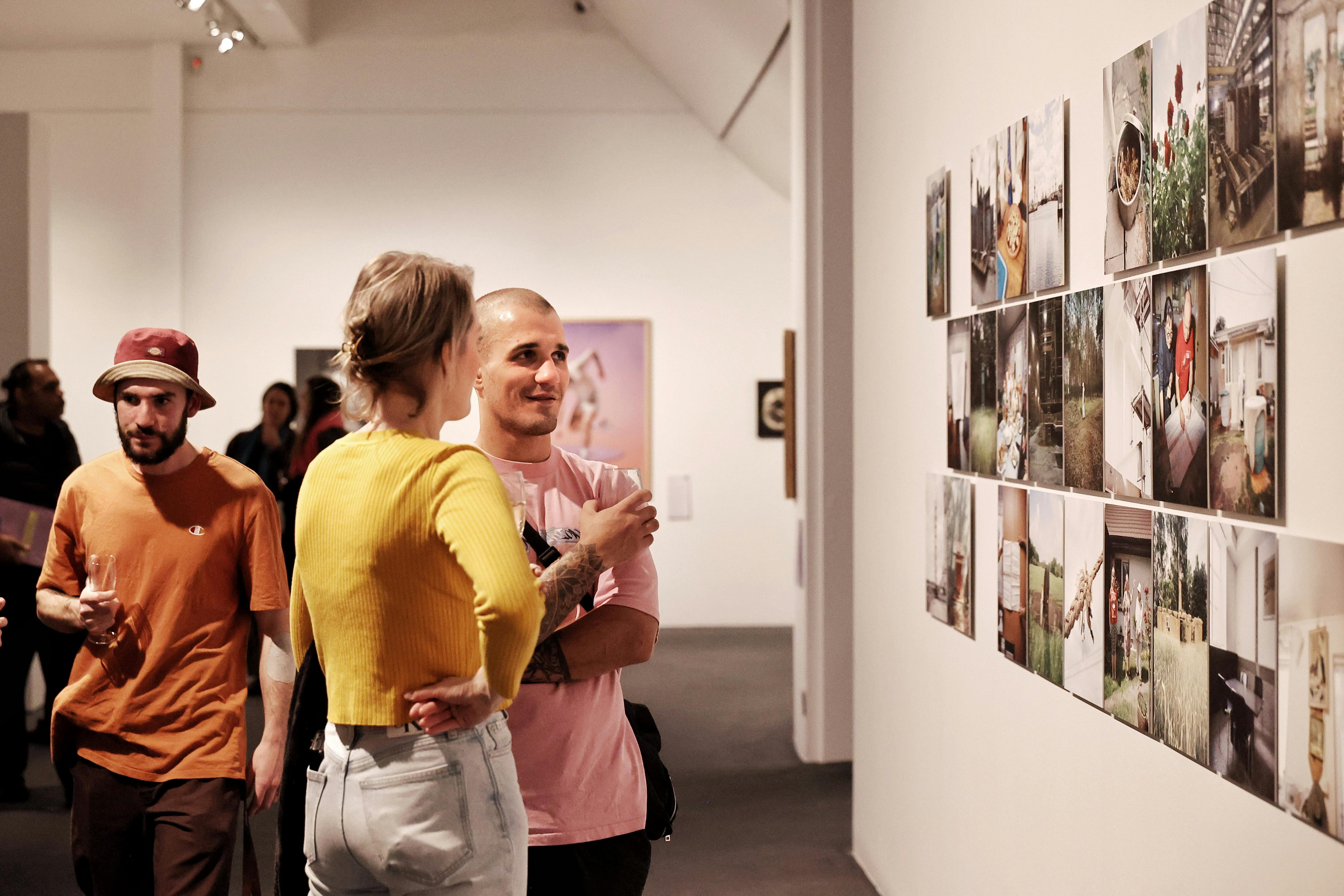Patrons chat while viewing artworks in the Bowness Photography Prize