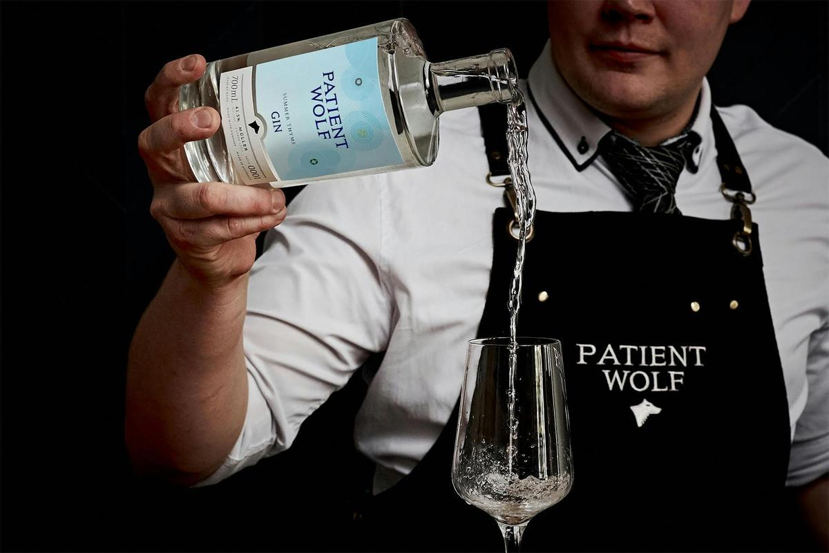 Patient Wolf Summer Thyme Gin pouring into a glass.