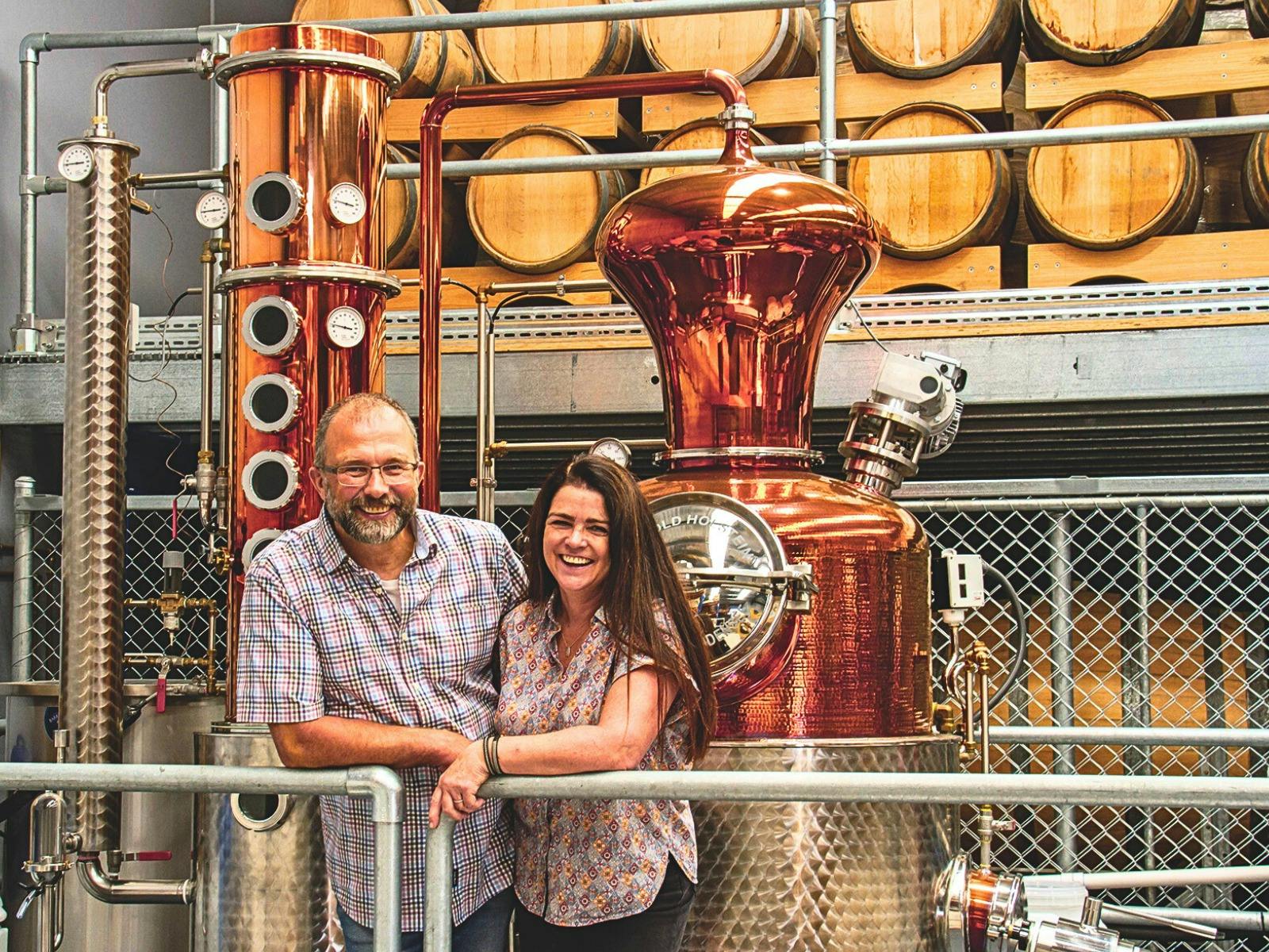 Christoph and Barbara - Founders of Original Spirit Co standing in their distillery surrounded by