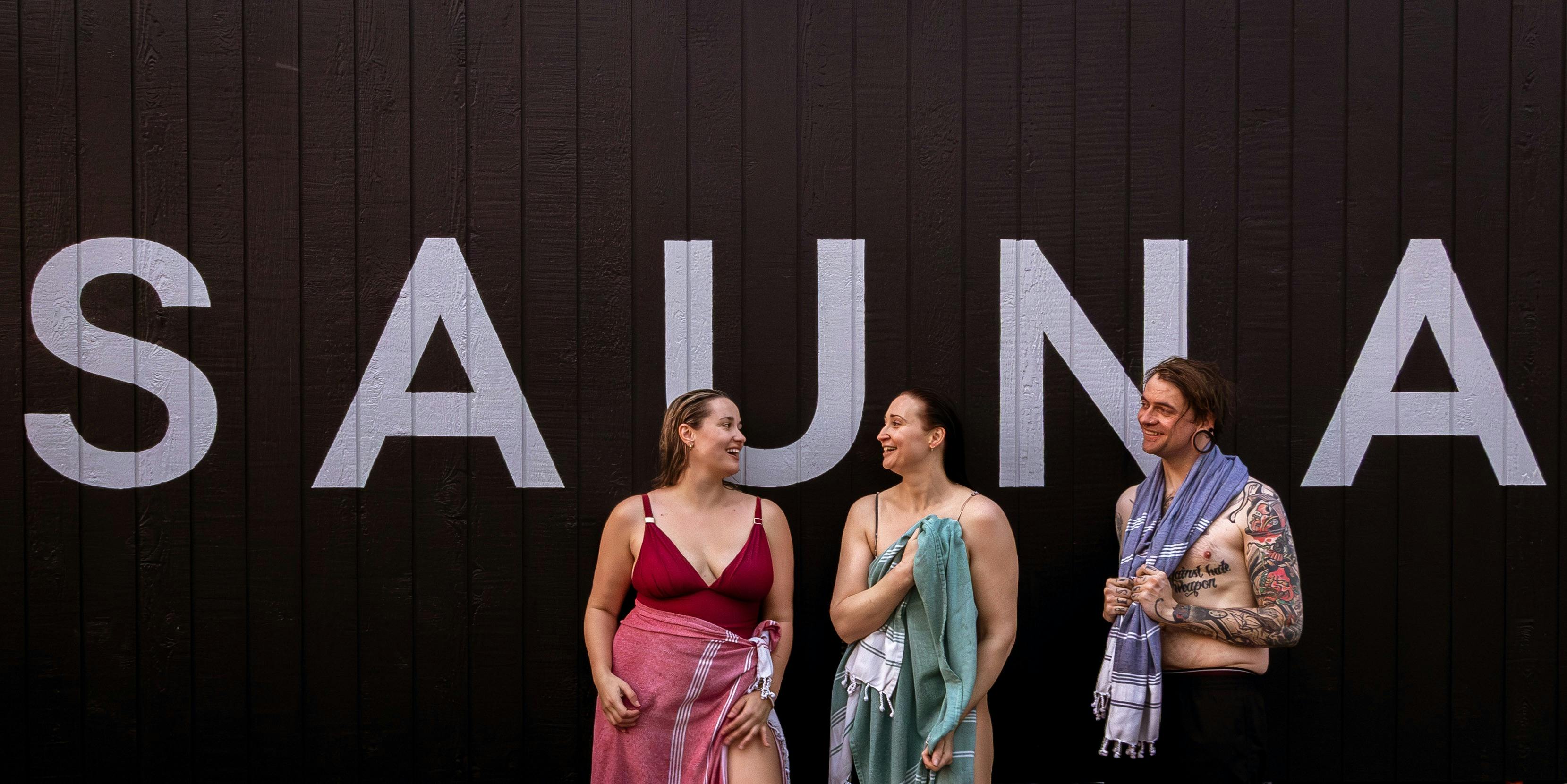 Guests in front of the sauna sign