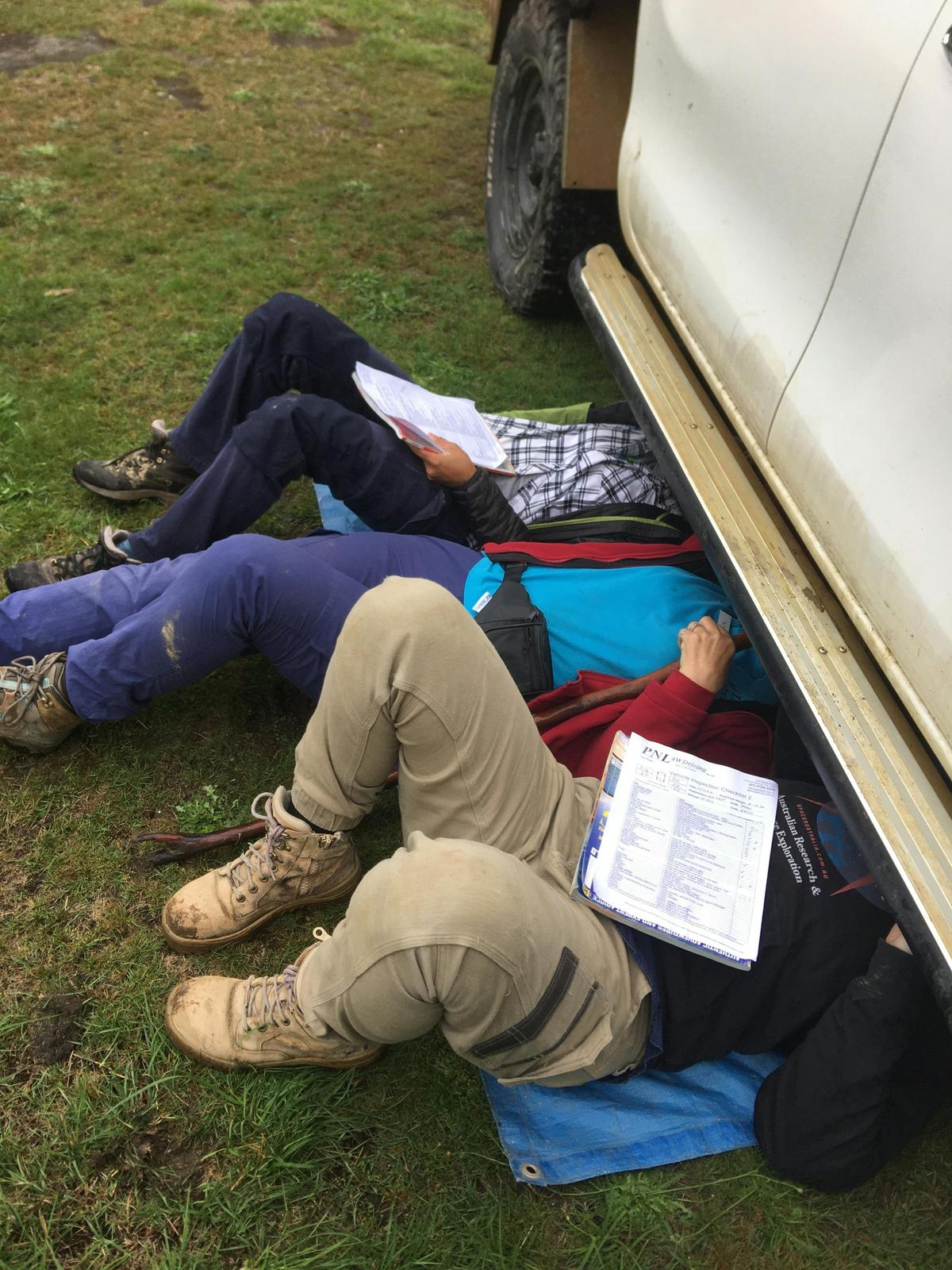 Instructor with participants, teaching them about how to inspect their vehicle.