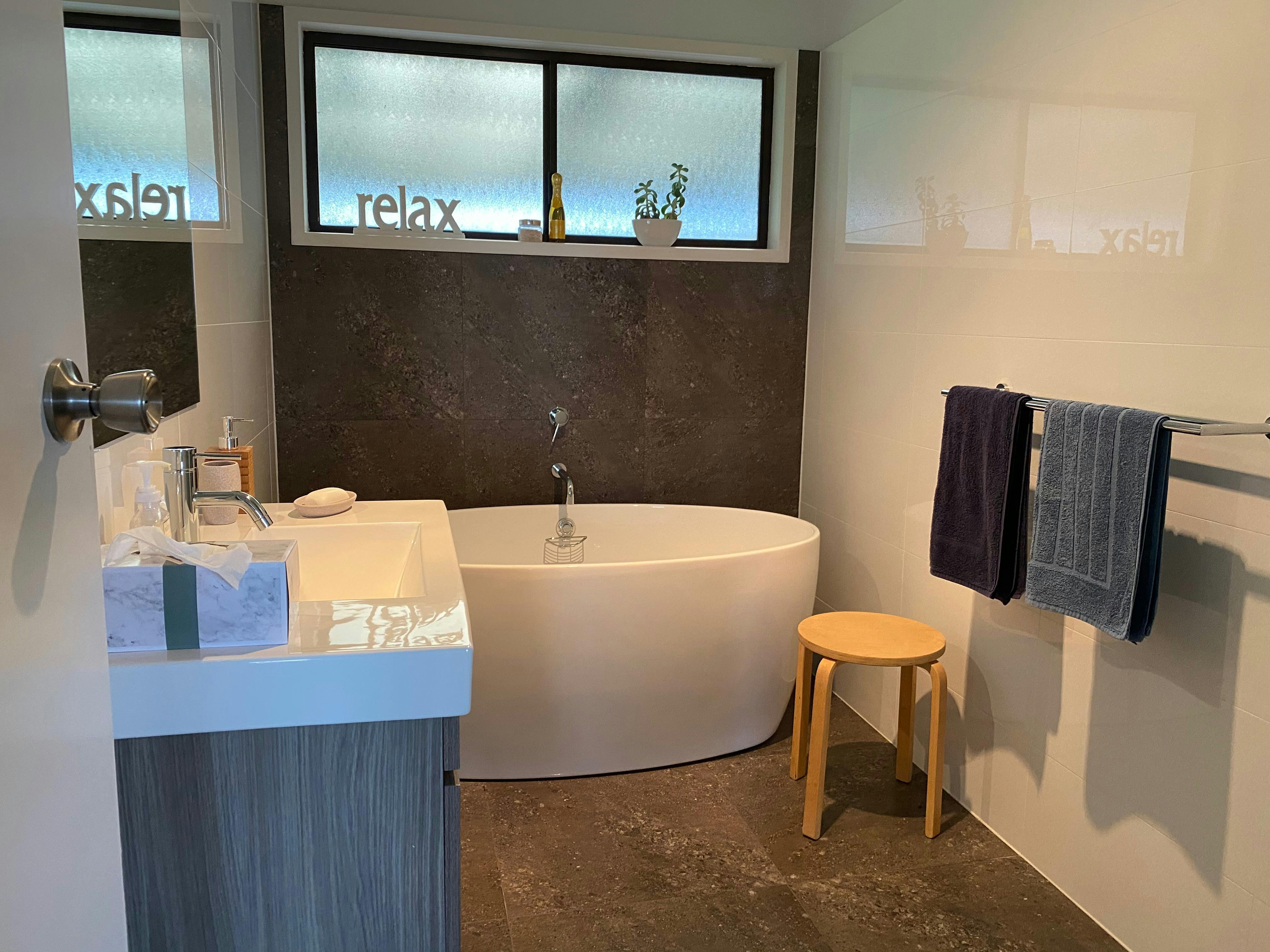 Luxury bathroom showing free-standing bath, vanity with mirror. There is a seperate shower facility