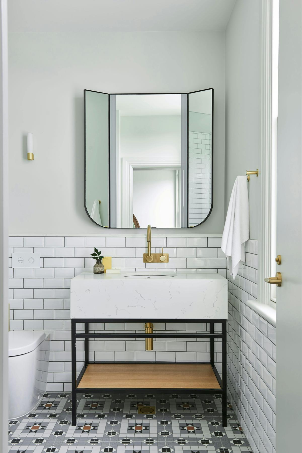 Bathroom mirror and vanity with brass fixtures
