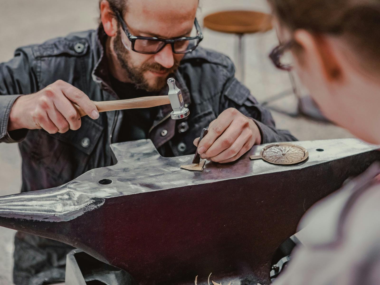 Man hammering metal on anvil