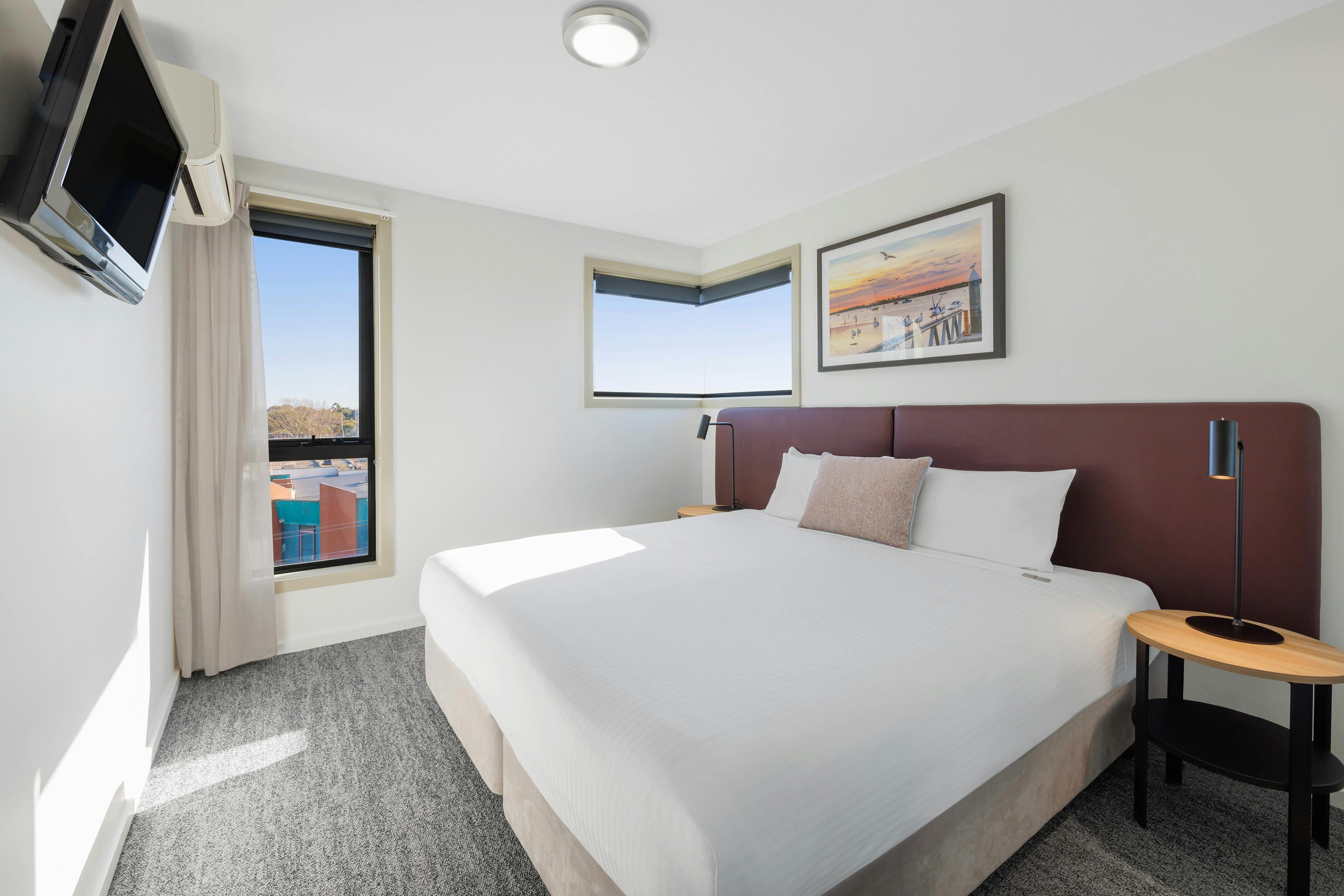 2-bedroom Apartment bedroom with a large bed, bedside tables and television