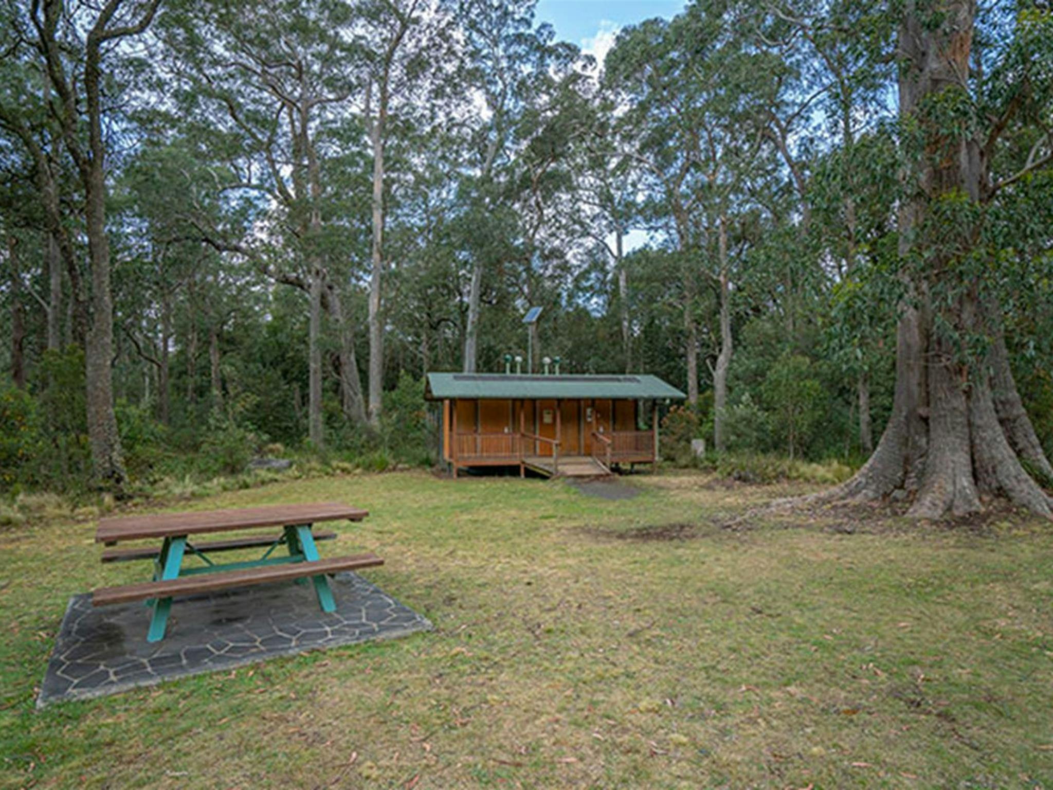 A picnic table and toilet facilities at Honeysuckle picnic area in Barrington Tops National Park.