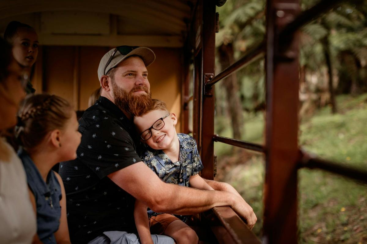 Father and son sitting and looking at views of forest