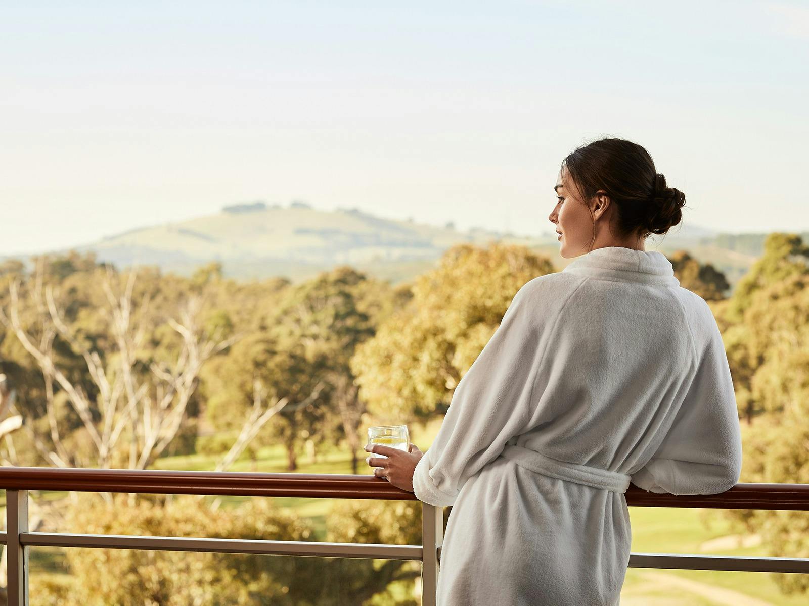 A woman enjoying the view from her Premium Fairway Suite