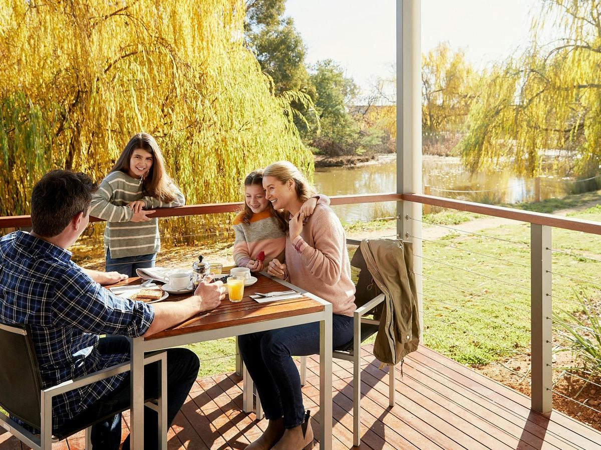 Family dining on deck of Lakeview Cabin