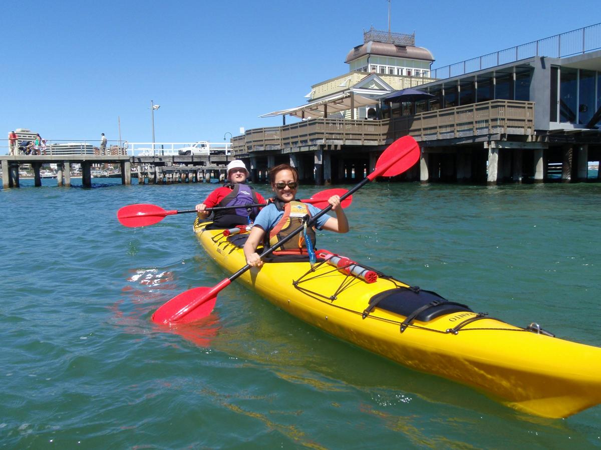 Kayaking past St Kilda kiosk on a St Kilda Sea Kayak Tour