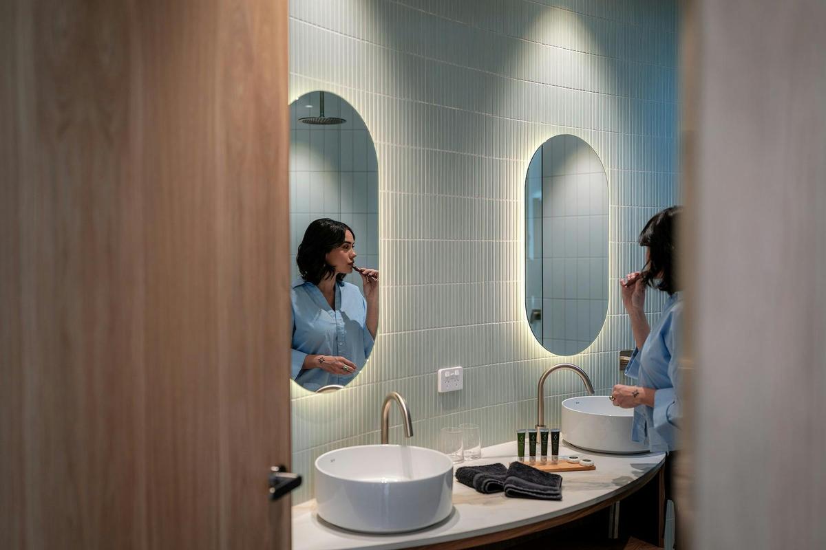 Woman brushing teeth in the bathroom at Retreat Studio at Chrismont