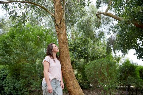 Woman looking up at trees