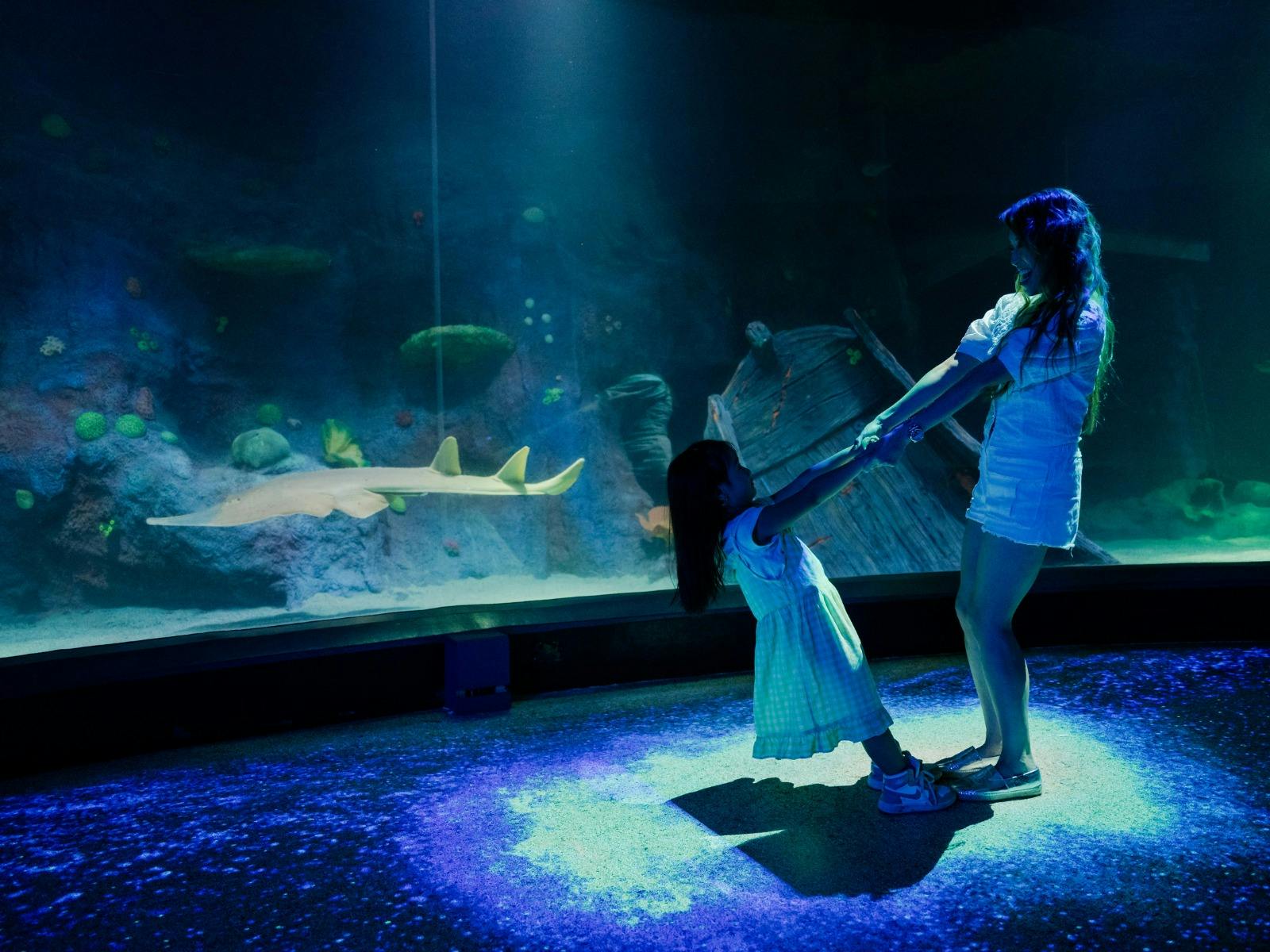 mother and daughter inside Night on the Reef exhibit.