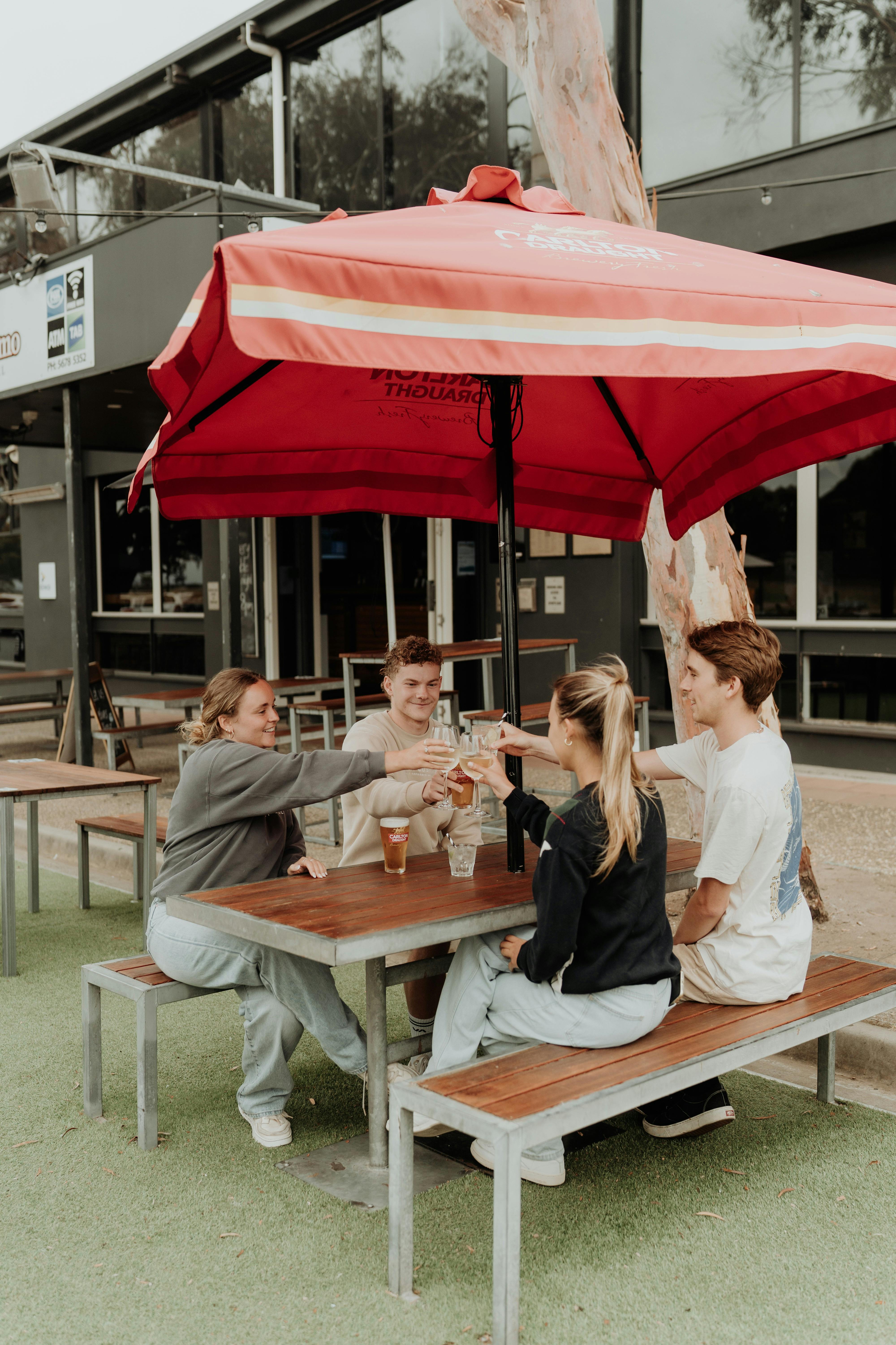 Group of 4 people sitting on an outdoor table