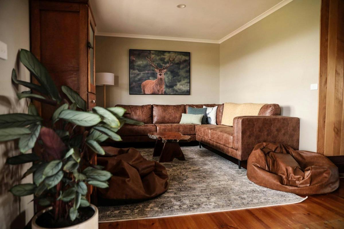 interior of a living room with a brown L-shaped couch and beanbag