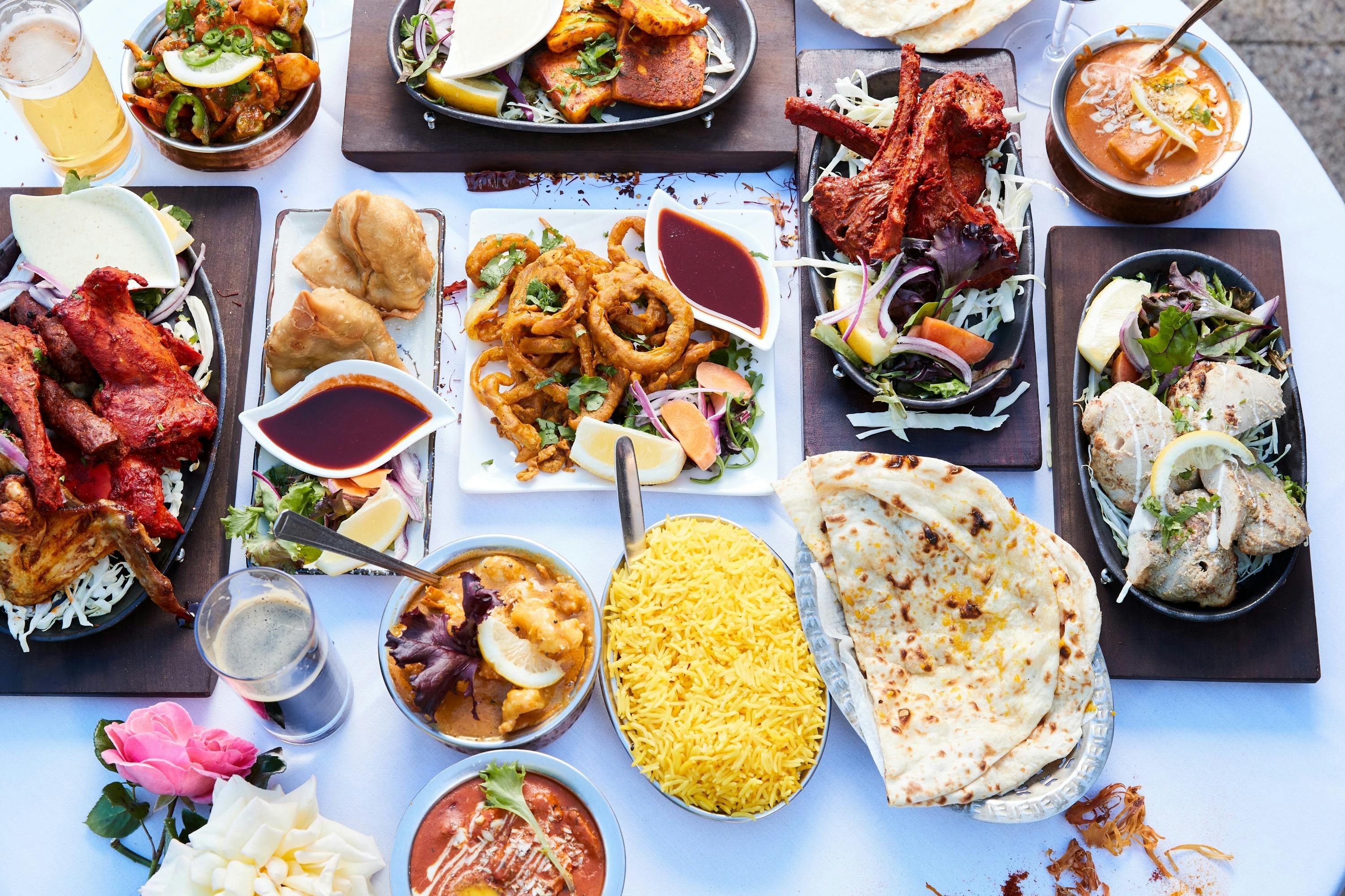 Banquet of Indian food with many brightly coloured different dishes.