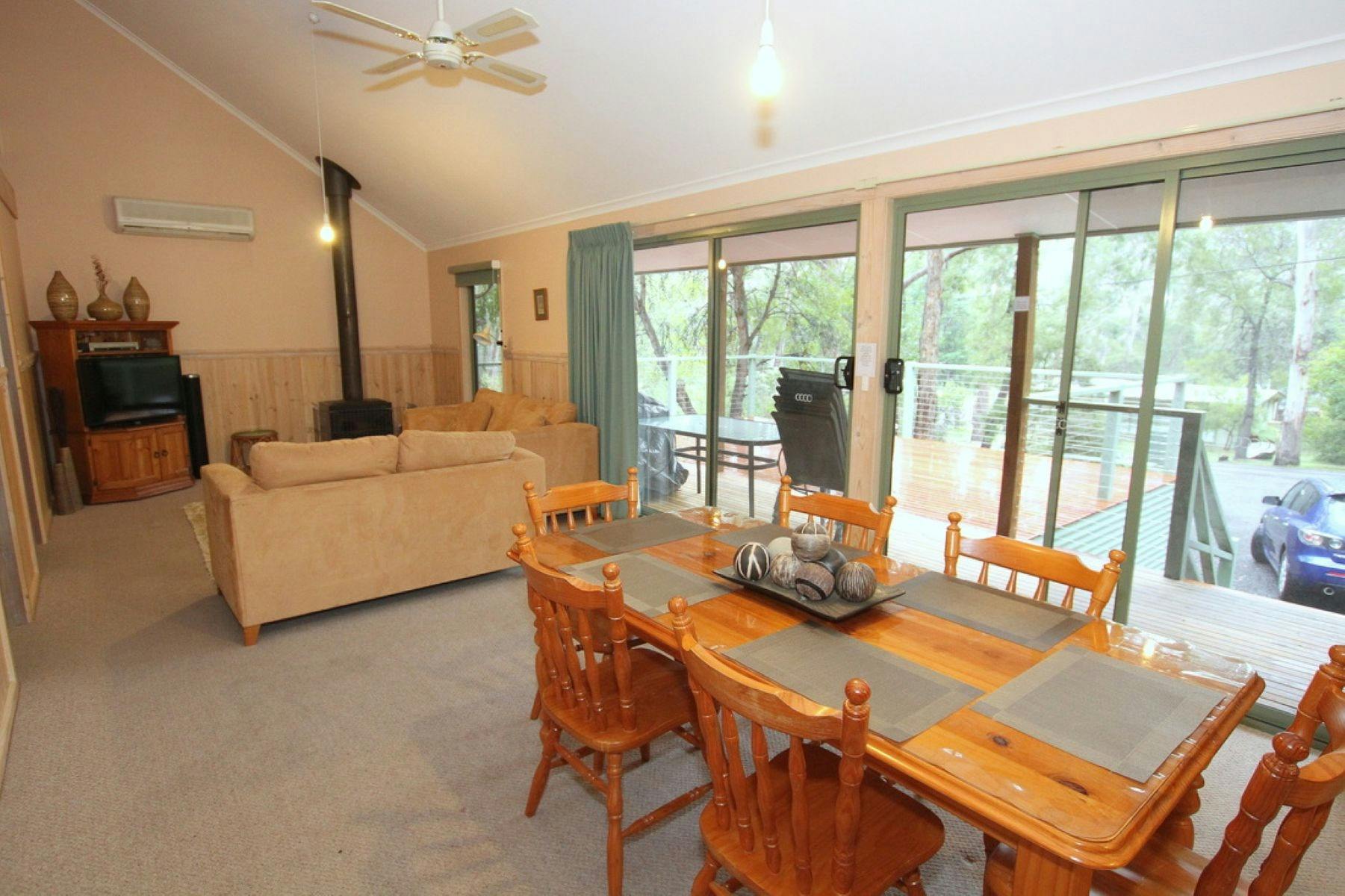 Dining table and chairs with wood fire and lounge suite in the background