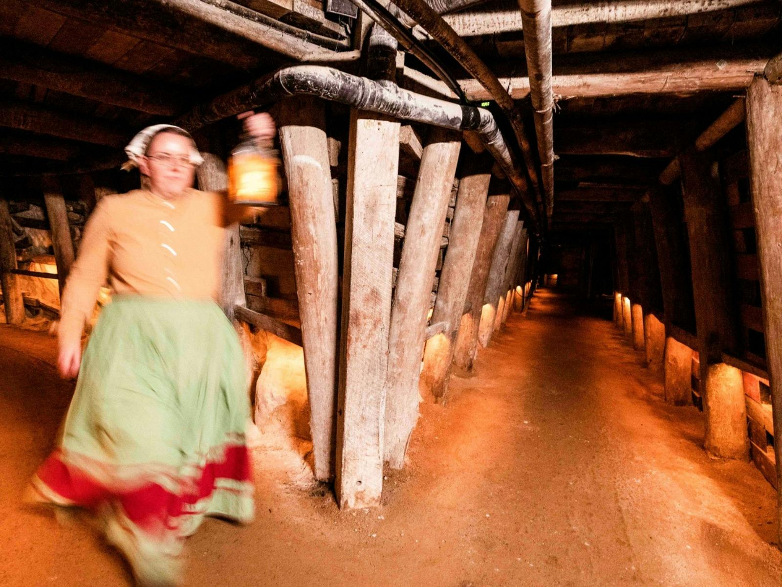Mine guide walking underground in mine shaft