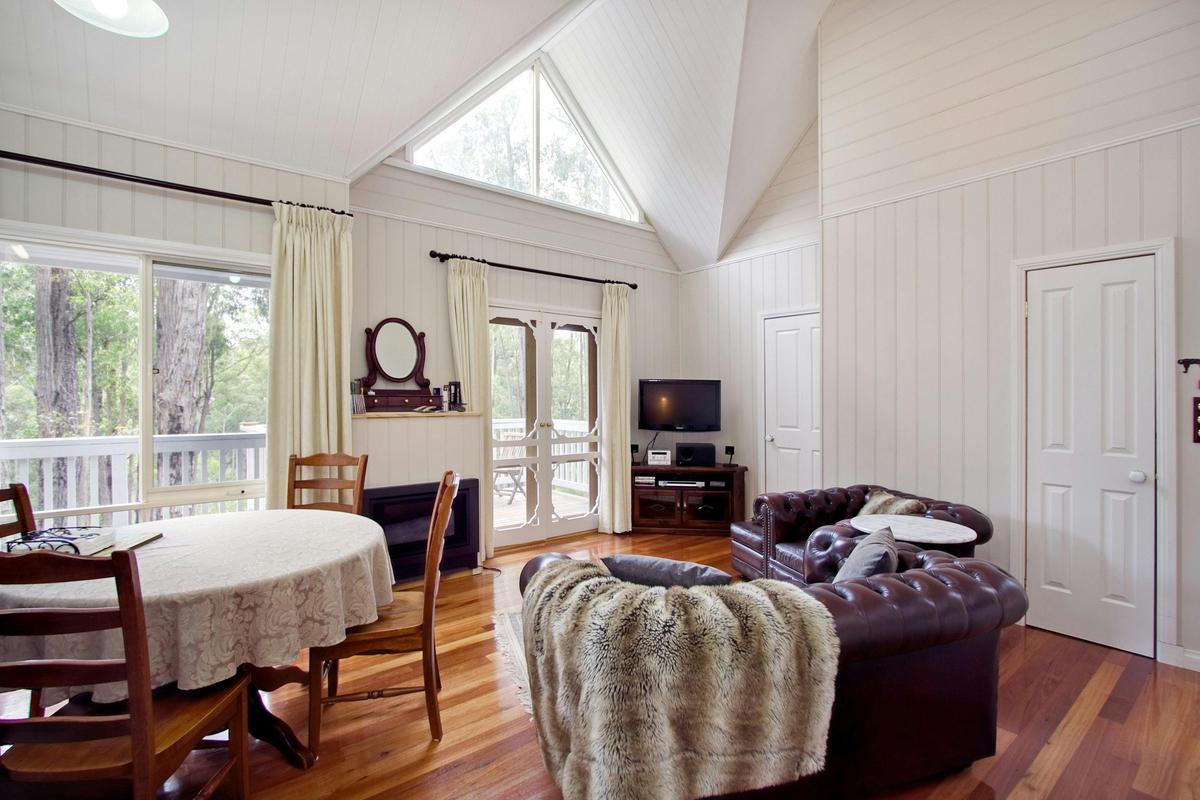 The spacious lounge of the One Bedroom Cottage leading to the balcony.