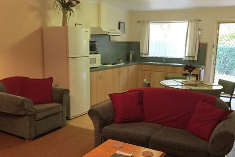 Lounge room with kitchen in the background