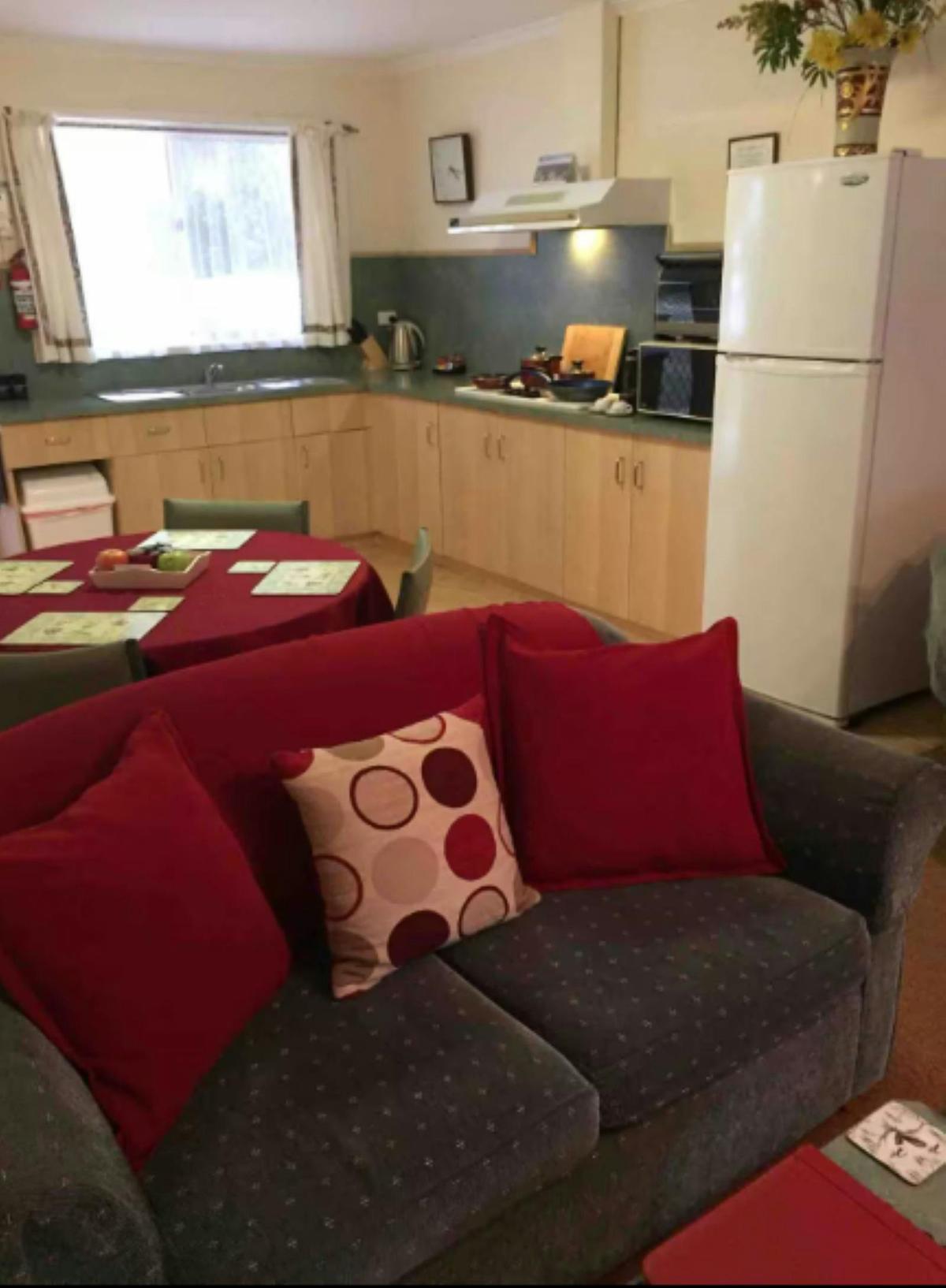 Couch in the foreground with a kitchen and small dining table