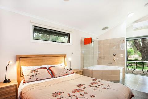 Queen bed is a couple of steps from the corner spa bat