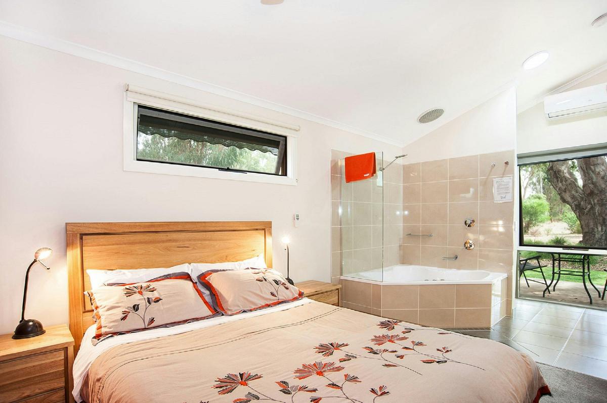 Queen bed is a couple of steps from the corner spa bat