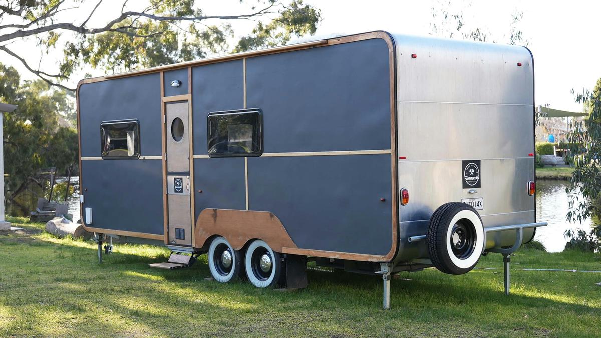HV1 silver caravan with wooden accents parked by the riverside at Stawell Grampians Gate Hotel Motel
