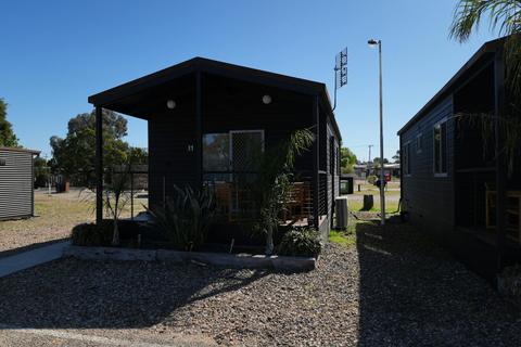 Cabin 1 with a shaded porch and outdoor seating at Stawell Grampians Gate Hotel Motel