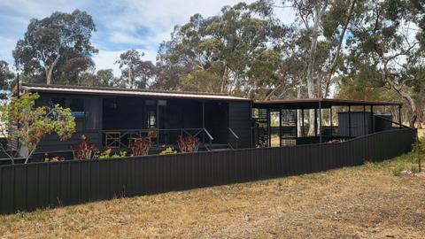 Spacious black cabin 88 with a large covered porch and yard at Stawell Grampians Gate Hotel Motel