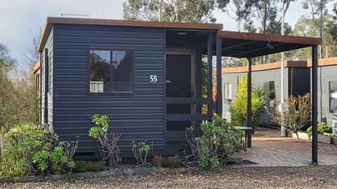 Black cabin 55 with a covered patio and garden plants at Stawell Grampians Gate Hotel Motel