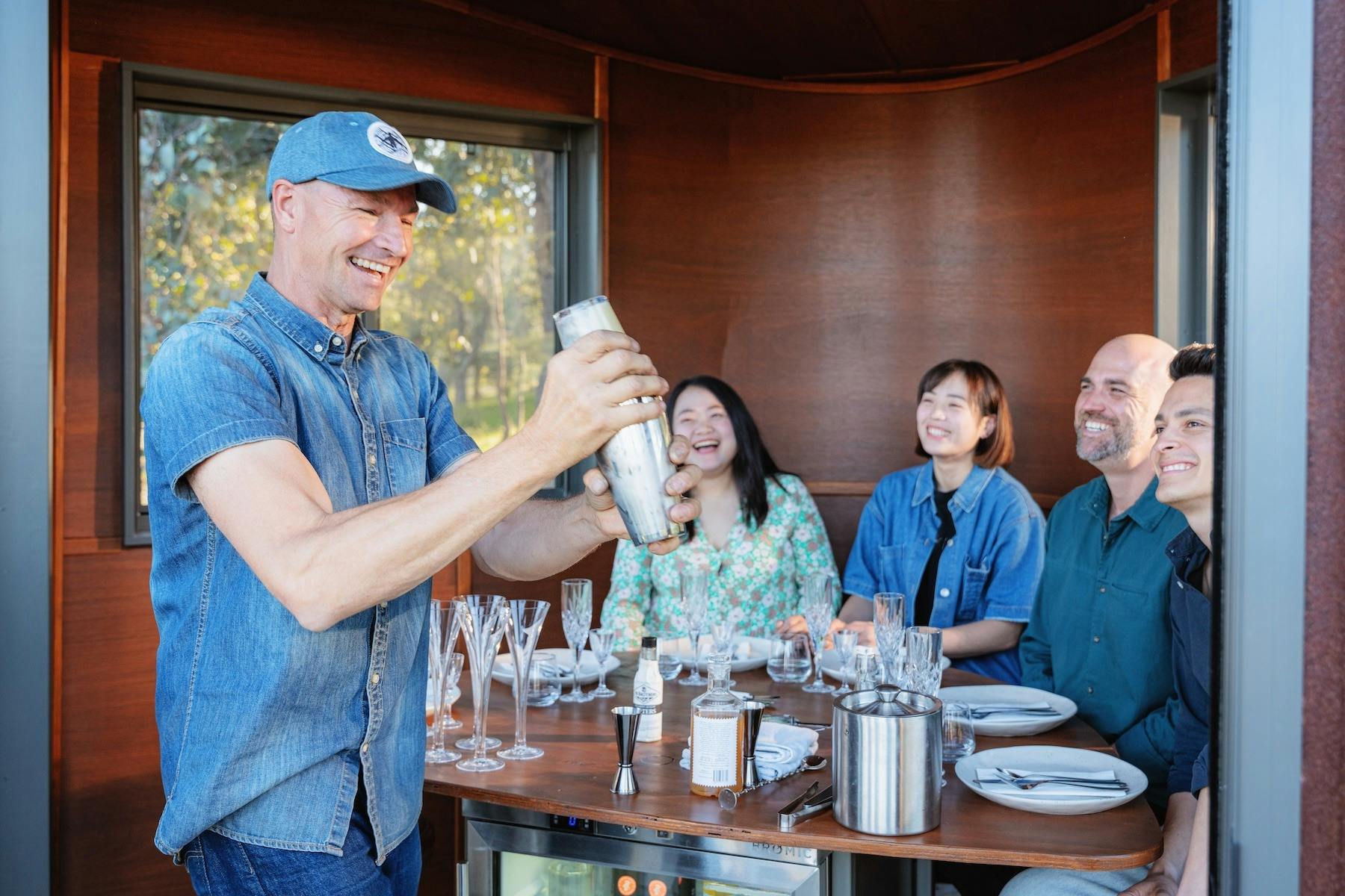 Hank shakes cocktails for guests inside the Swiftcrest Tasting Pod experience.