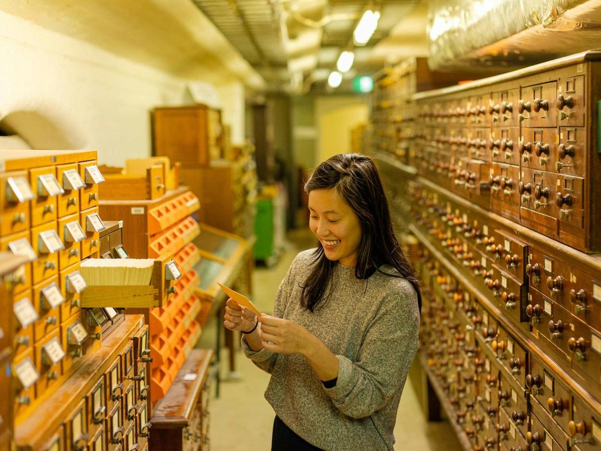 Tour attendee searching through the heritage card catalogue room