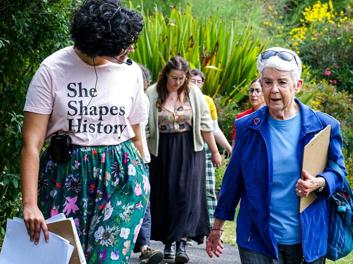 She Shapes History tour guide speaking to a guest as they walk