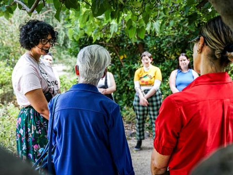 She Shapes History tour guide speaking with a group of engaged guests