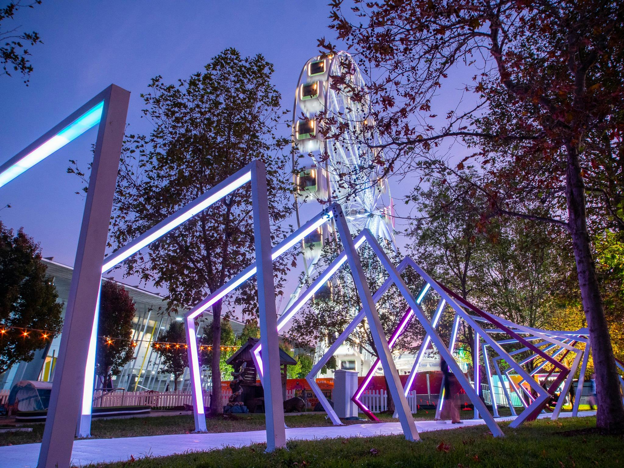 Night shot of ferris wheel and light tunnel