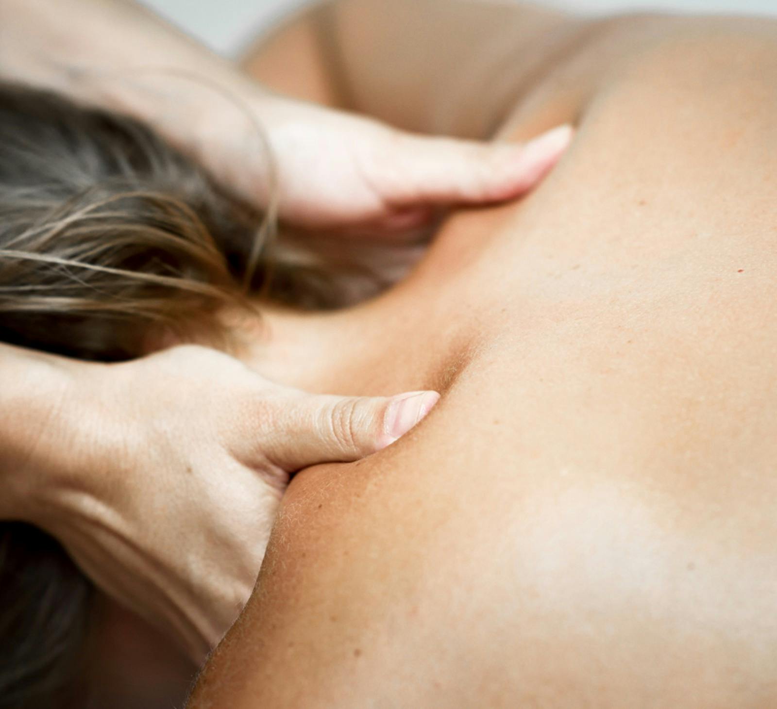 Photo of hands on shoulders of someone receiving a relaxing massage