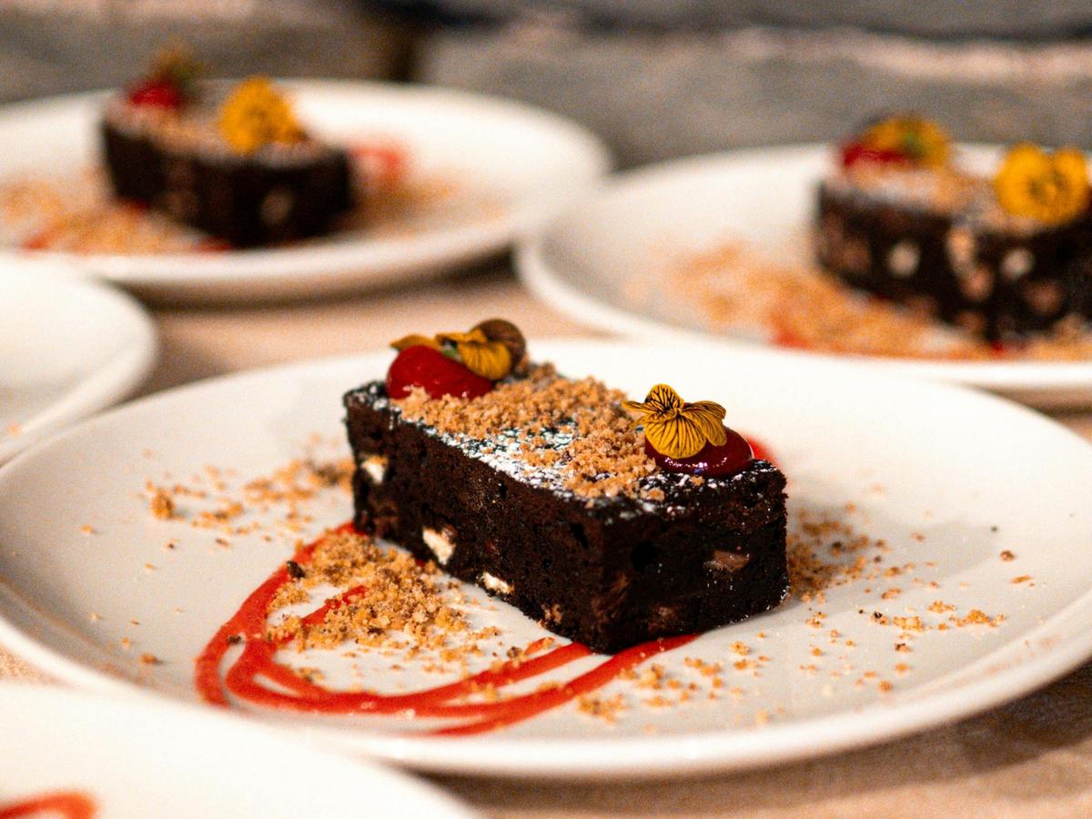 Image of brownie dessert with red berries and cookie crumble on top