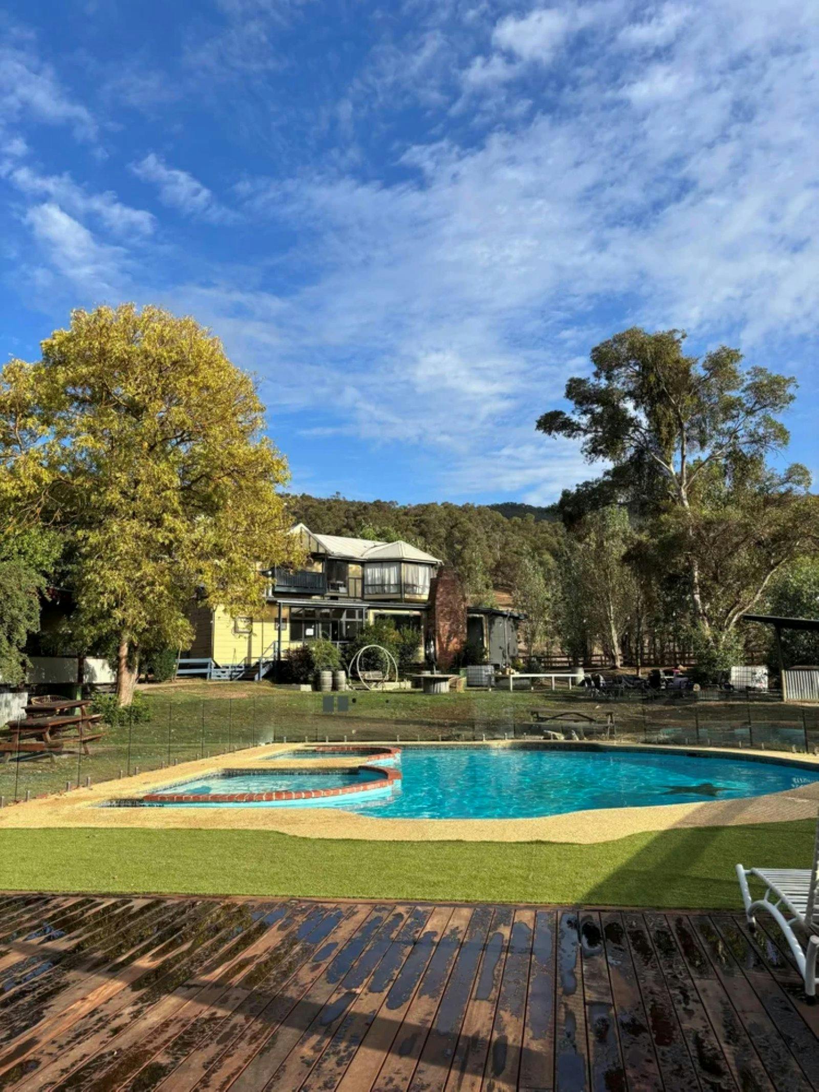 exterior of house surrounded by bushland with a pool in front of it