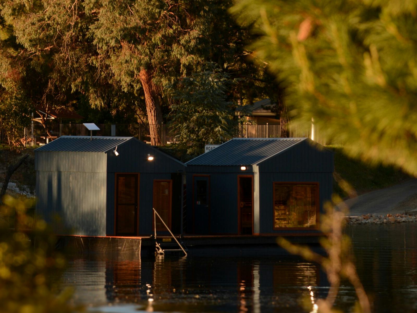 Exterior view of the Stillwater Saunas floating sauna on Lake Sambell in Beechworth, surrounded by n