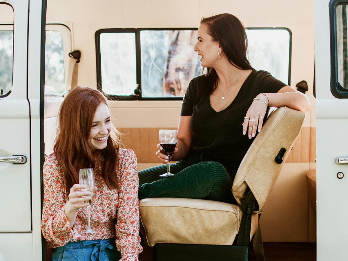 2 guests sharing a wine in the kombi