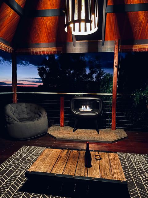 Brand-new outdoor sunset view area featuring French fireplace, atmospheric lighting & clawfoot bath