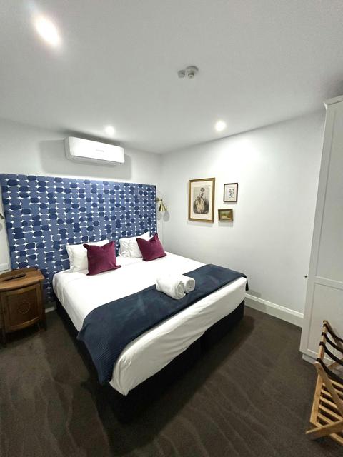 Bedroom with bed, bed side tables and towels placed on the bed